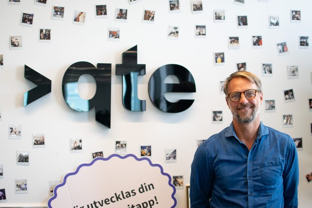 Pehr Dunger står framför en vägg med logotypen för Qte.