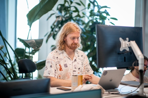 En utvecklare på qte sitter och arbetar vid sitt skrivbord.