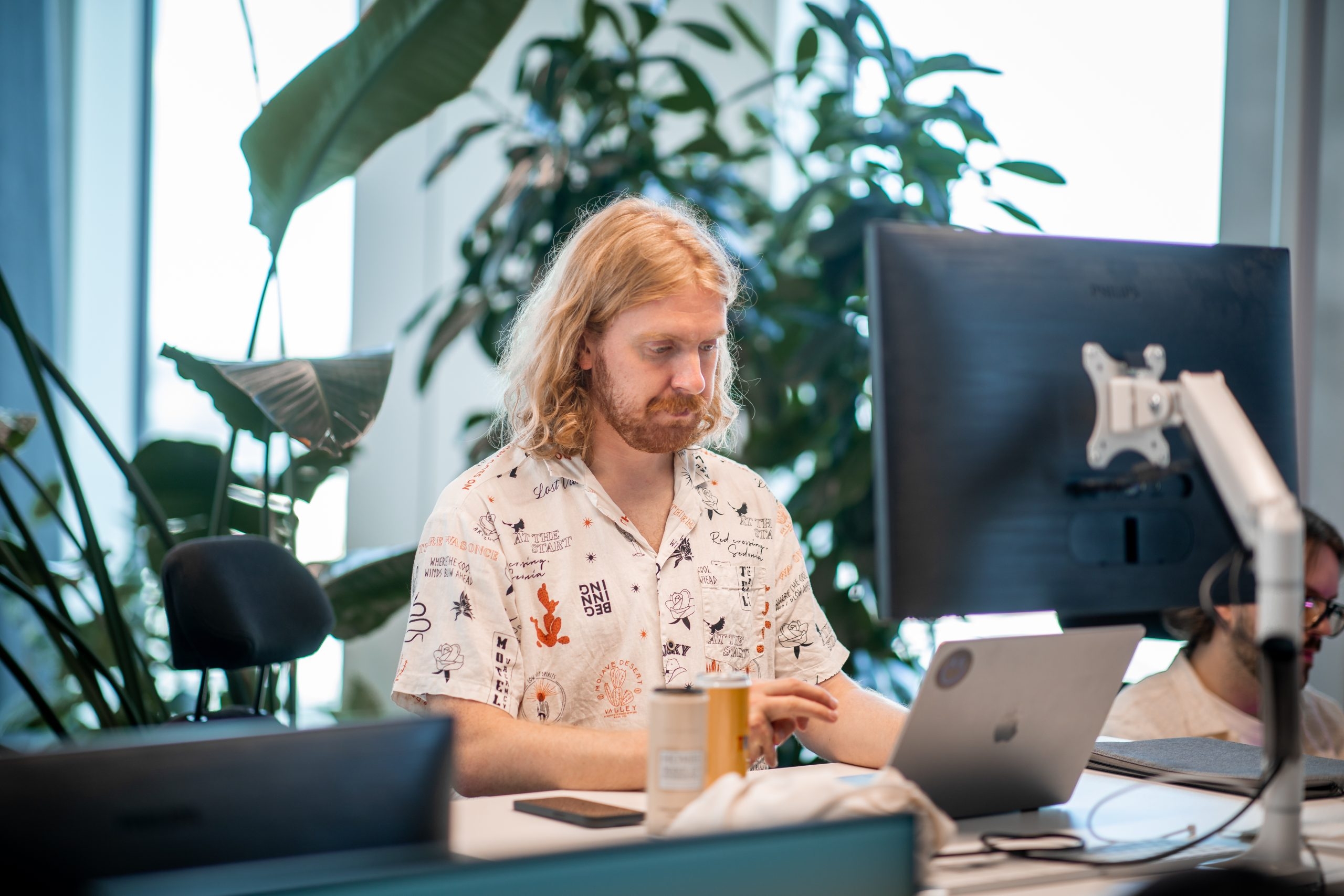 En utvecklare på qte sitter och arbetar vid sitt skrivbord.