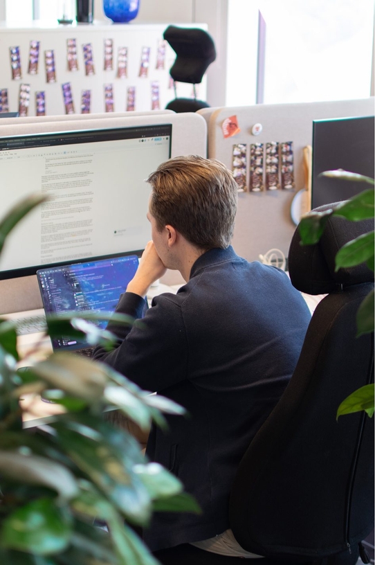 En utvecklare på qte sitter och jobbar vid sitt skrivbord.